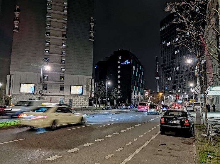 Street view at night, with cars blurred in the photo.