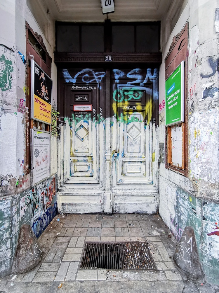 Front door of an old building covered with graffiti.