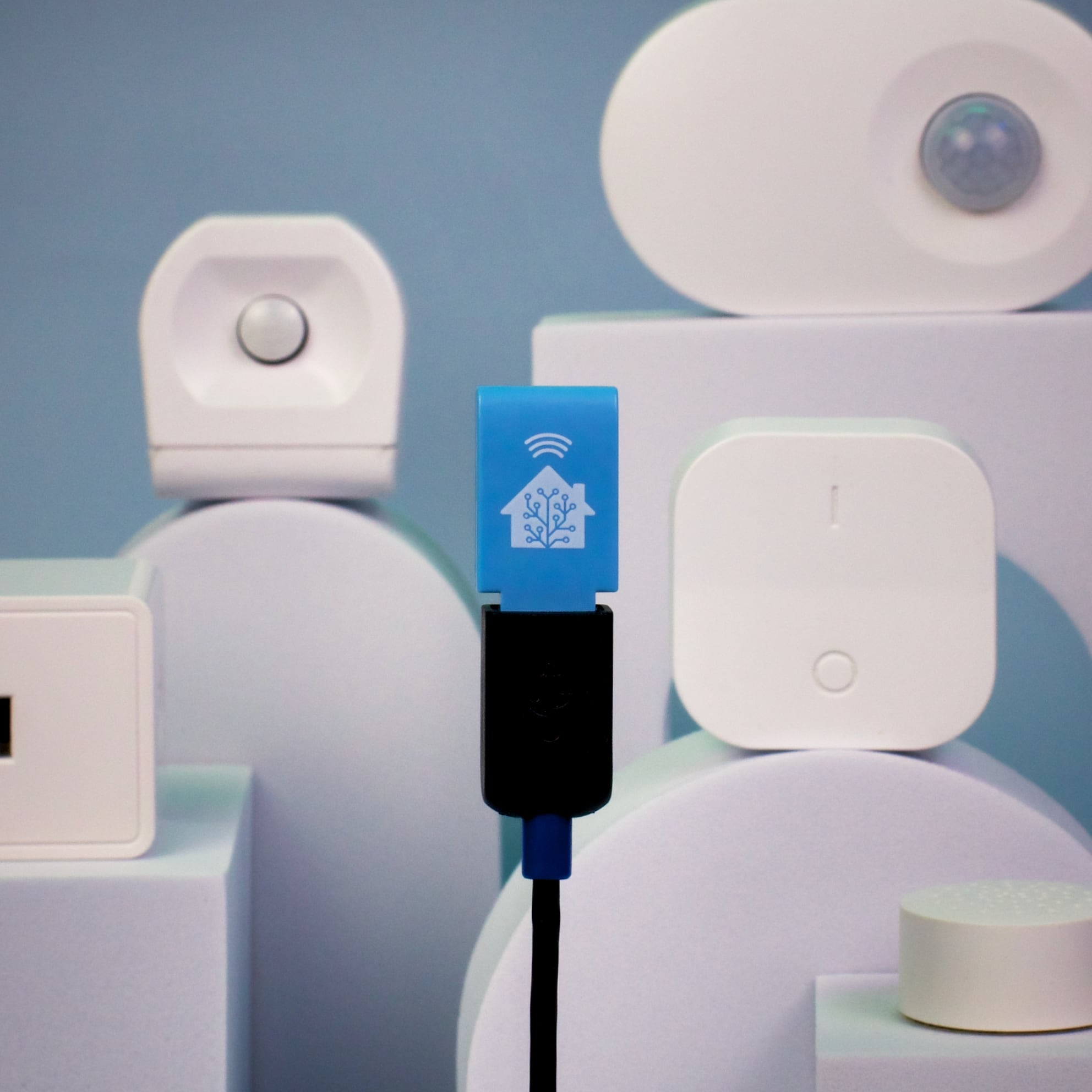 Image of the Zigbee USB stick hovering in the air with IoT devices behind it