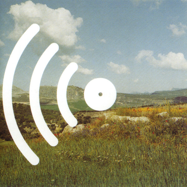 Photography of a pastoral landscape, with a mountain far away and a blue sky with large white clouds, and with a white, large graphical icon on top of the photo, resembling the typical symbol someone would use for the diffusion of sound.