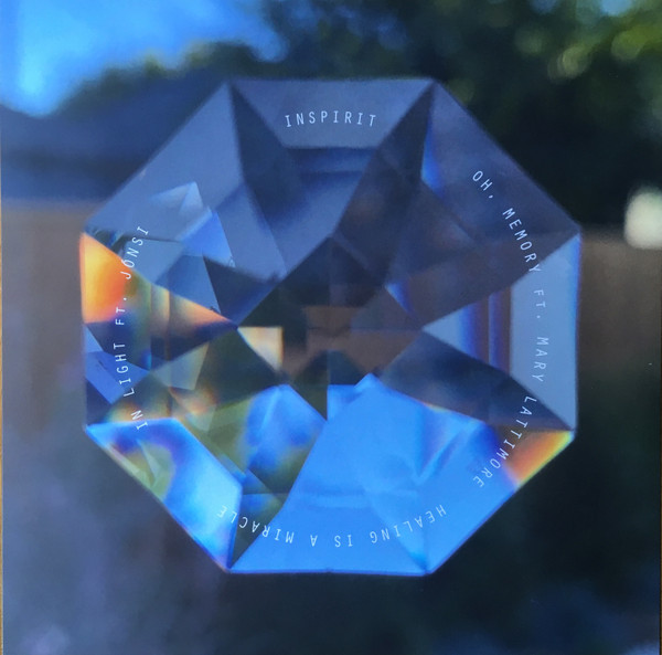 Photo of a diamond that is very close to the camera. The composition is symmetrical and background is blurred. On top of the diamond is the side A track listing. The color scheme is in the blue tones with some accents of orange, probably from the sunset.